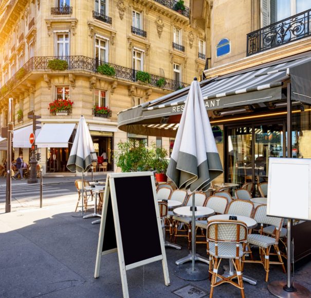 River Cruise Seine Parisian street with tables of brasserie (cafe) in Paris