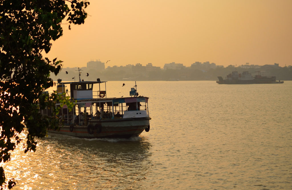 Boat sailing over river ganges during sunset.