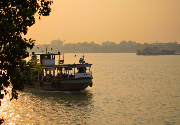 Boat sailing over river ganges during sunset.