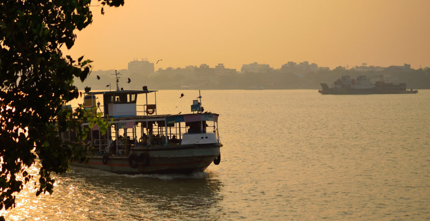 Boat sailing over river ganges during sunset.