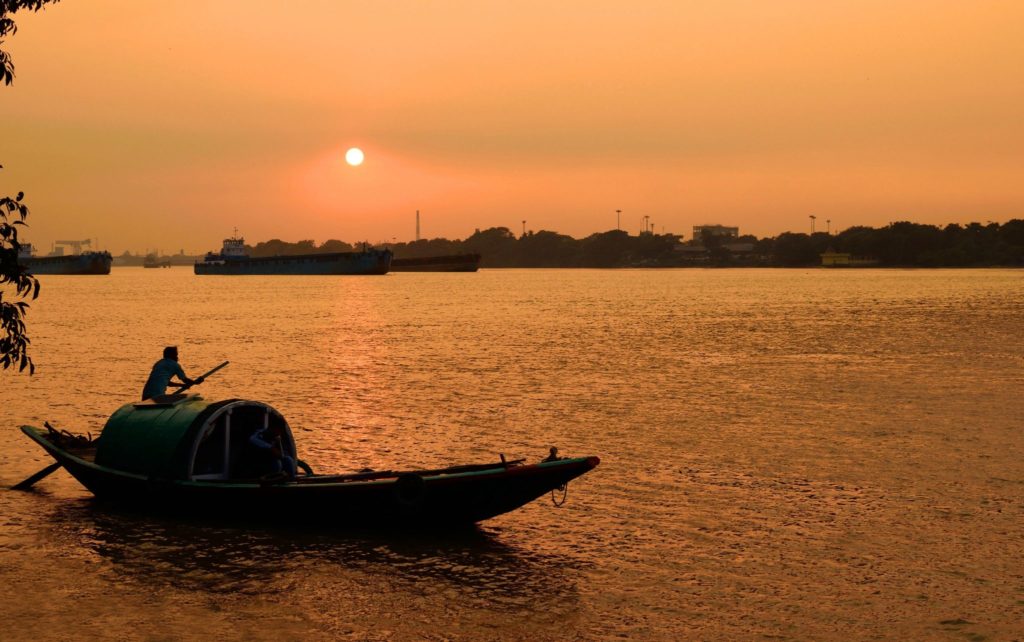 Silhouette of a fisherman riding a boat during sunset Ganges
