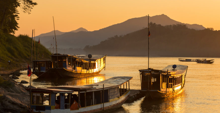 Boats on the Mekong river at dusk. (APT Essential Vietnam & Cambodia tour)